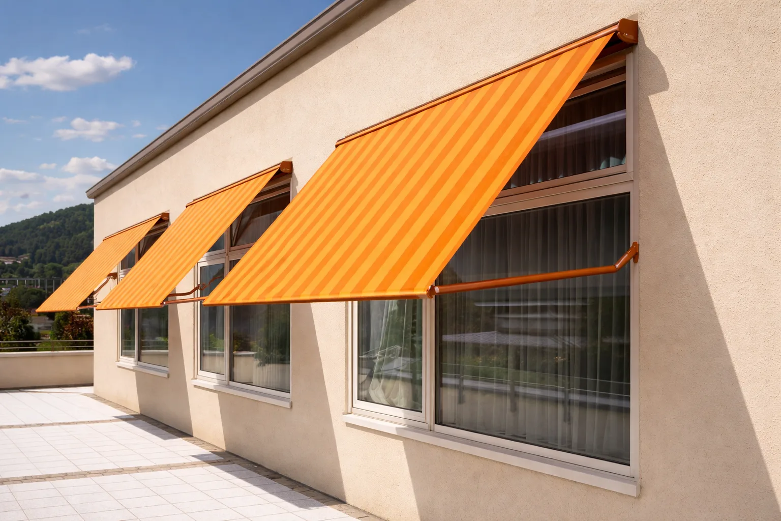 Fenstermarkisen mit orangefarbenem Sonnenschutz an einer Hausfassade in Wien